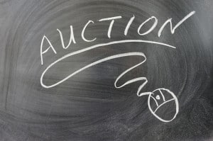 Auction word and mouse symbol on chalkboard representing online auctions for selling land